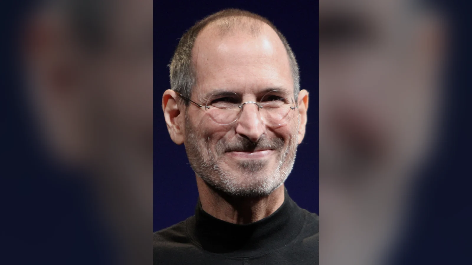 Steve Jobs sonriendo con jersey negro y gafas en 2010, para su carta astral y su astrocartografía